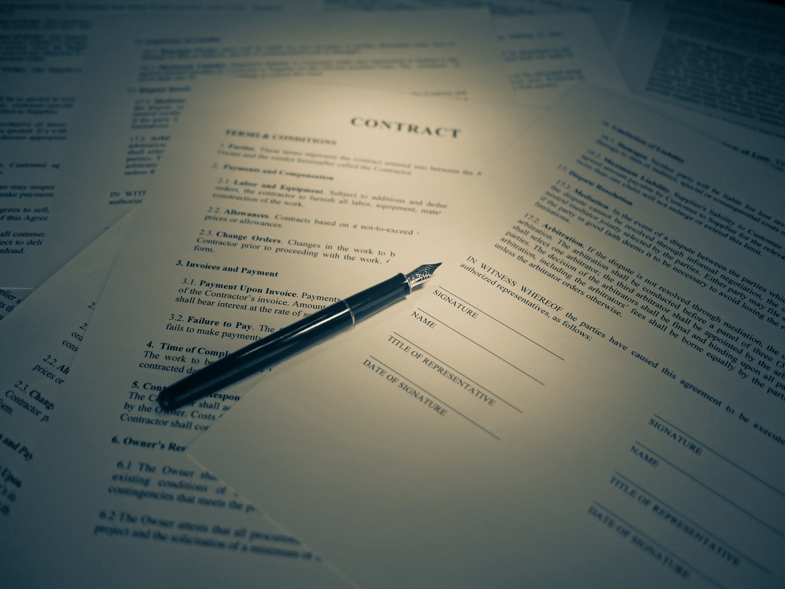 Persona firmando un contrato de compraventa sobre un escritorio